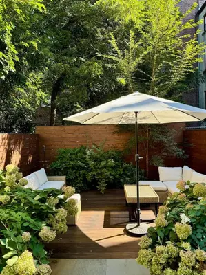 a patio with an umbrella and chairs and a table at Luxury Oasis in Manhattan in New York