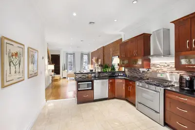 a large kitchen with wooden cabinets and stainless steel appliances at Luxury Oasis in Manhattan in New York
