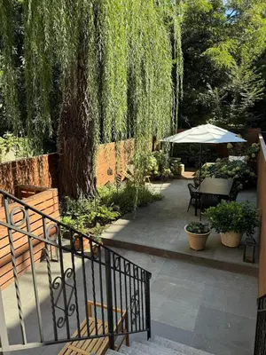 a patio with a table and an umbrella and a tree at Luxury Oasis in Manhattan in New York