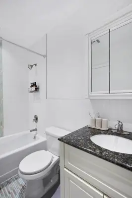 a white bathroom with a toilet and a sink at Luxury Oasis in Manhattan in New York