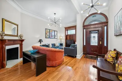 a living room with a couch and a fireplace at Luxury Townhouse in NYC in New York