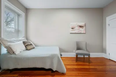 a bedroom with a bed and a chair and a window at Luxury Townhouse in NYC in New York