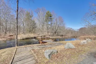 a wooden bridge over a river in a forest at Close to Trails Studio with Water Views in Wurtsboro