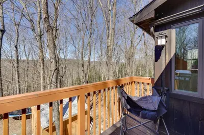 a rocking chair on the deck of a cabin at Hike and Fish Outdoor Retreat Near Trails in Wurtsboro
