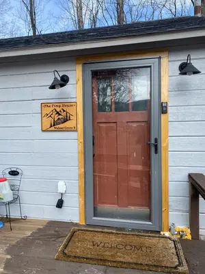a front door of a house with a sign on it at Tiny house of Walnut Grove in Ashland