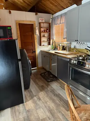 a kitchen with a black refrigerator and a sink at Tiny house of Walnut Grove in Ashland