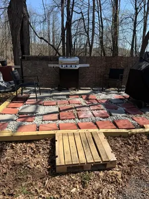 a stone patio with a grill and a bench at Tiny house of Walnut Grove in Ashland