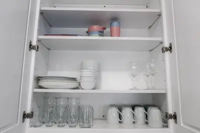 a cupboard filled with glasses and plates and dishes at 8BR 4BA Home Near NYC -Sleeps 16 in Irvington