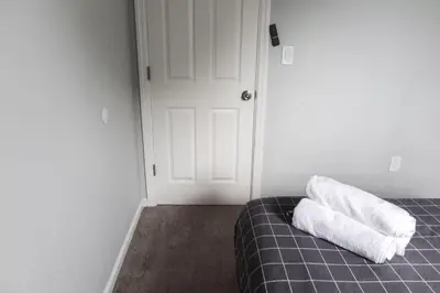 a room with a bed with two towels on it at 5Bed 2Bath Near NYC, Parking, Laundry in Irvington