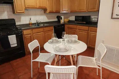 a kitchen with a white table with chairs and a sink at 1Bed 1Bath Apt near EWR, Parking 18 min from Penn St. in Newark