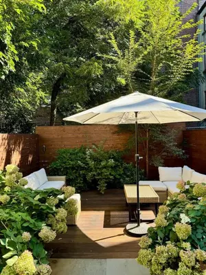 a patio with an umbrella and chairs and a table at Luxury Oasis in Manhattan in New York