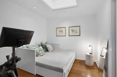 a white room with a bed and a tv on a tripod at Luxury Oasis in Manhattan in New York