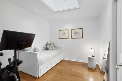 a white bedroom with a bed and a flat screen tv at Luxury Oasis in Manhattan in New York