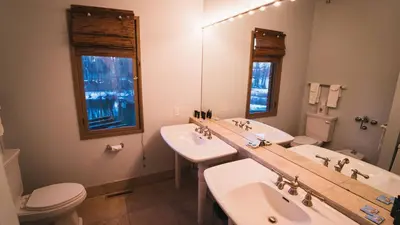 a bathroom with two sinks and a toilet and a mirror at Butter Milk Falls Inn and Spa in Milton