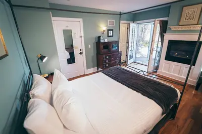a bedroom with a large bed and a fireplace at Butter Milk Falls Inn and Spa in Milton