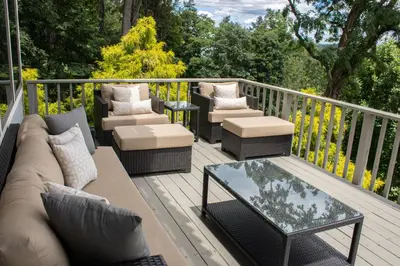 a deck with chairs and a couch and a table at Butter Milk Falls Inn and Spa in Milton