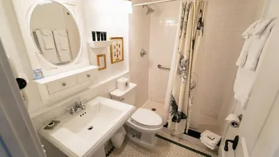 a bathroom with a sink and a toilet and a mirror at Butter Milk Falls Inn and Spa in Milton