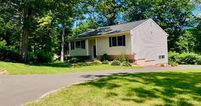 a small white house with a yard and a driveway at Country House in Waterbury