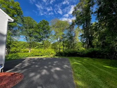 a driveway leading to a yard with trees at Country House in Waterbury