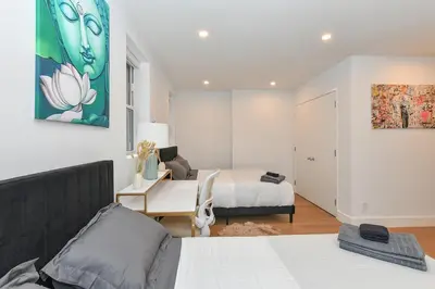 a bedroom with a bed and a desk and a room with a bed at Sophisticated 3 Bedroom Duplex in the Heart of Midtown in New York