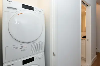 a washing machine in a room with a mirror at Sophisticated 3 Bedroom Duplex in the Heart of Midtown in New York