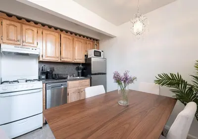 a kitchen with a wooden table and white appliances at Amazing Furnished 1 BR Midtown West in New York