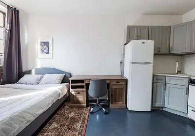 a bedroom with a bed and a desk and a refrigerator at Cozy Studio! Steps to Central Park & Upper E Side!, June To Aug 90 Days Stay Required in New York
