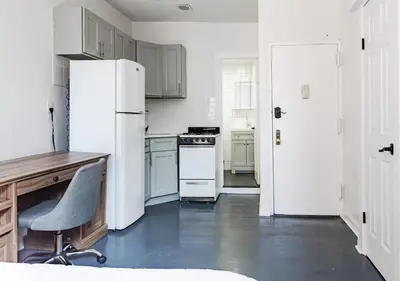 a kitchen with a refrigerator and a desk and a chair at Cozy Studio! Steps to Central Park & Upper E Side!, June To Aug 90 Days Stay Required in New York