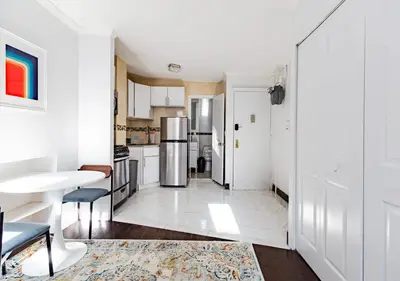 a kitchen with a refrigerator and a table at Spacious Upper East Side Studio, June To Aug 90 Days Stay Required in New York