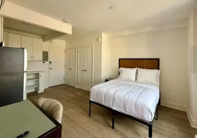 a small bedroom with a bed and a kitchen at Close to Times Square! Stunning Studio in NYC! in New York