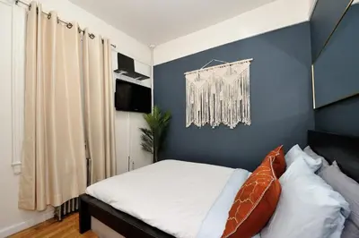 a bedroom with a bed with a blue wall at Furnished 2 Bedroom Apartment in Lennox Hill, June To Aug 90 Days Stay Required in New York