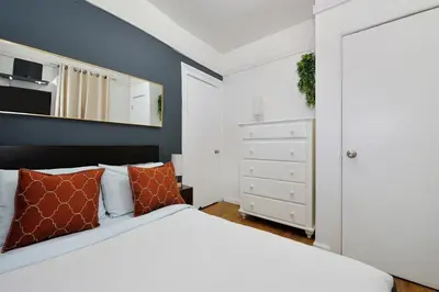 a bedroom with a white bed and a white closet at Furnished 2 Bedroom Apartment in Lennox Hill, June To Aug 90 Days Stay Required in New York