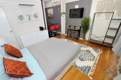 a small room with a bed and a television at Furnished 2 Bedroom Apartment in Lennox Hill, June To Aug 90 Days Stay Required in New York