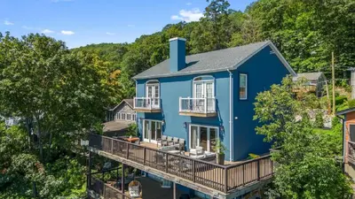 an aerial view of a blue house with a deck at Lakeview Villa with Private Hot Tub, Firepit & Breathtaking Cliff Views in Greenwood Lake