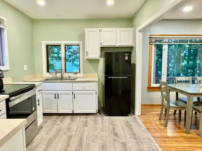 a kitchen with a black refrigerator and a table at Cayuga lake cottage with private lake access in Washingtonville