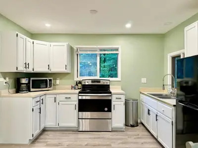 a kitchen with white cabinets and a stove at Cayuga lake cottage with private lake access in Washingtonville