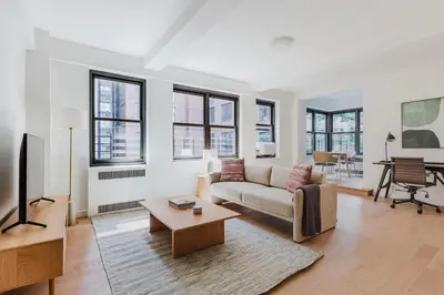 a living room with a couch and a table at Blueground Midtown E wd doorman nr E River NYC-1527 in New York
