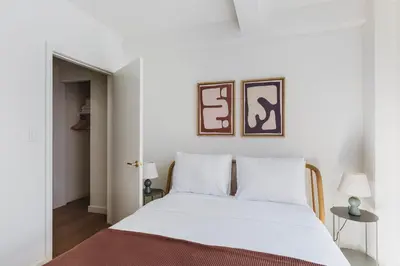 a bedroom with a white bed with the number six on the wall at Blueground Midtown E wd doorman nr E River NYC-1527 in New York
