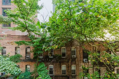an old brick building with trees in front of it at Blueground Midtown E wd doorman nr E River NYC-1527 in New York