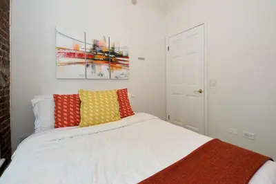 a bedroom with a white bed with colorful pillows at Midtown West 3 Bedroom Washer dryer and Dishwasher, June to Aug 90 days stay required in New York