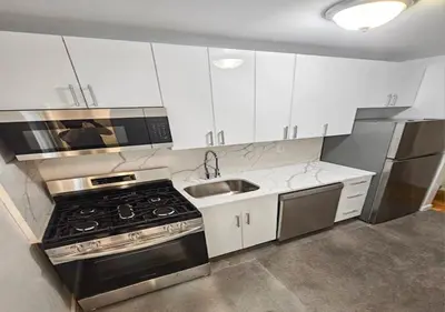 a kitchen with white cabinets and a stove and a sink at Midtown West 3 Bedroom Washer dryer and Dishwasher, June to Aug 90 days stay required in New York