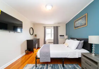 a bedroom with a white bed and a blue wall at Midtown West 3 Bedroom Washer dryer and Dishwasher, June to Aug 90 days stay required in New York
