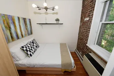 a small room with a bed and a window at Midtown West 3 Bedroom Washer dryer and Dishwasher, June to Aug 90 days stay required in New York