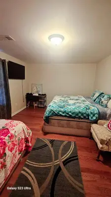 a bedroom with two beds and a flat screen tv at Divine Villa and Resort - 32 Evergreen in Newark