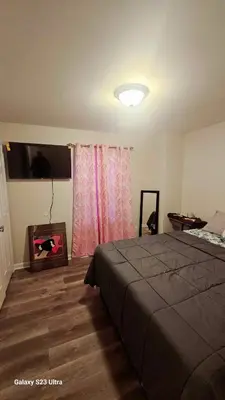 a bedroom with a bed and a television in it at Divine Villa and Resort - 32 Evergreen in Newark