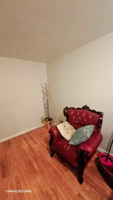 a red leather chair in a room with wooden floors at Divine Villa and Resort - 32 Evergreen in Newark