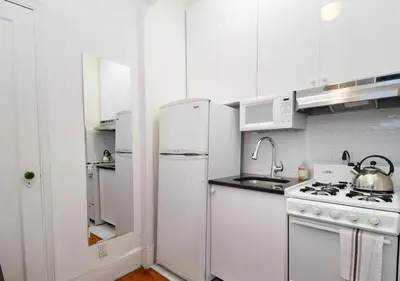 a kitchen with white cabinets and a white refrigerator at Outdoor Space Washer Dryer Dishwasher 3Beds Apt, June to Aug 90 days stay required in New York