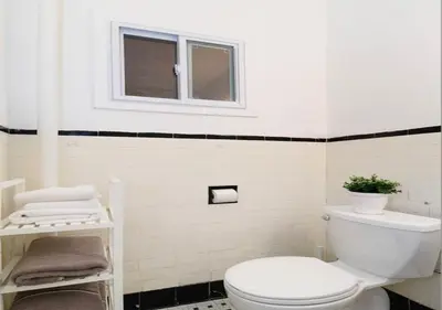 a bathroom with a white toilet and a window at Outdoor Space Washer Dryer Dishwasher 3Beds Apt, June to Aug 90 days stay required in New York