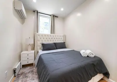 a bedroom with a large bed and a window at Amazing Location Murray Hill 3 Bedroom Apartment ,June to Aug 90 days stay required in New York