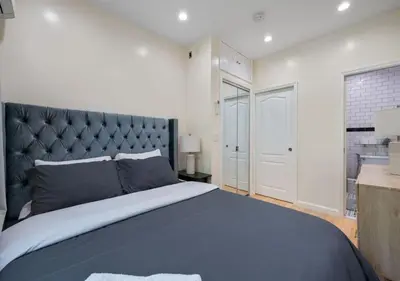 a bedroom with a large bed with a blue blanket at Amazing Location Murray Hill 3 Bedroom Apartment ,June to Aug 90 days stay required in New York